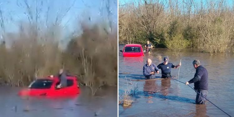 Bomberos rescataron con cuerdas y arneses a un conductor atrapado por la crecida de un curso de agua en el puente La Picada, en Colonia